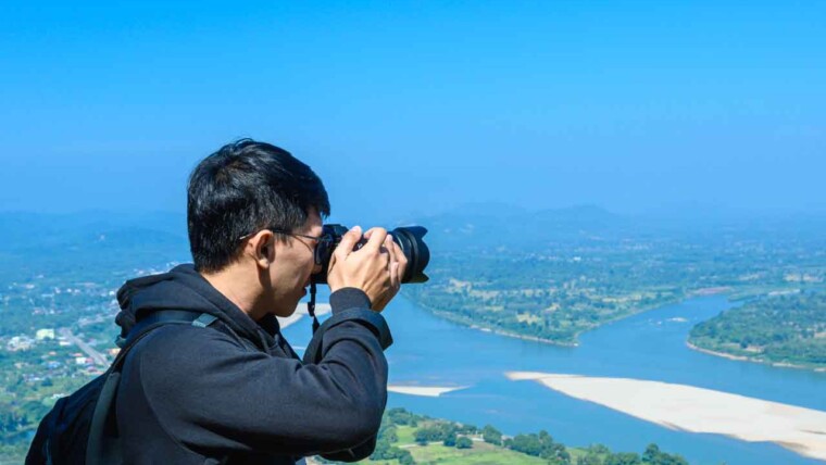 A photographer capturing a stunning travel shot during golden hour with a DSLR camera, emphasizing the key aspects of travel photography.