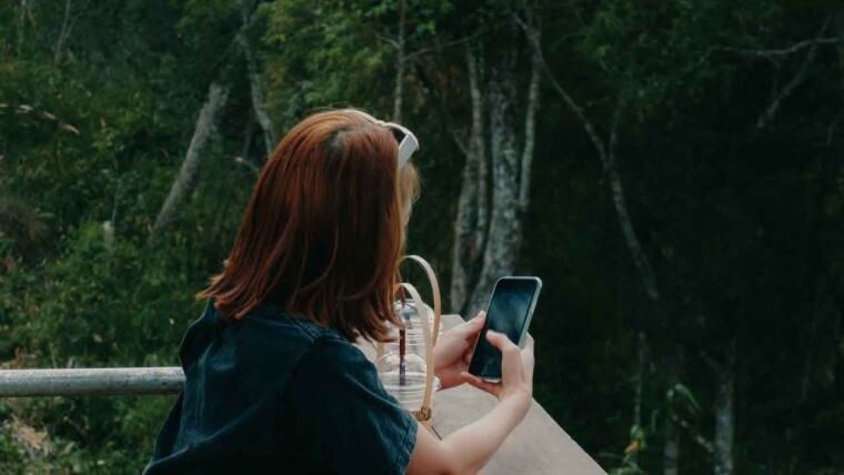 A traveler using a local travel app on their smartphone while exploring a new city.